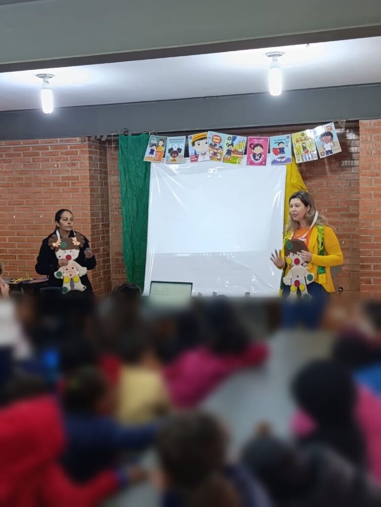 Oficina com bonecos, com a turma sentada em frente