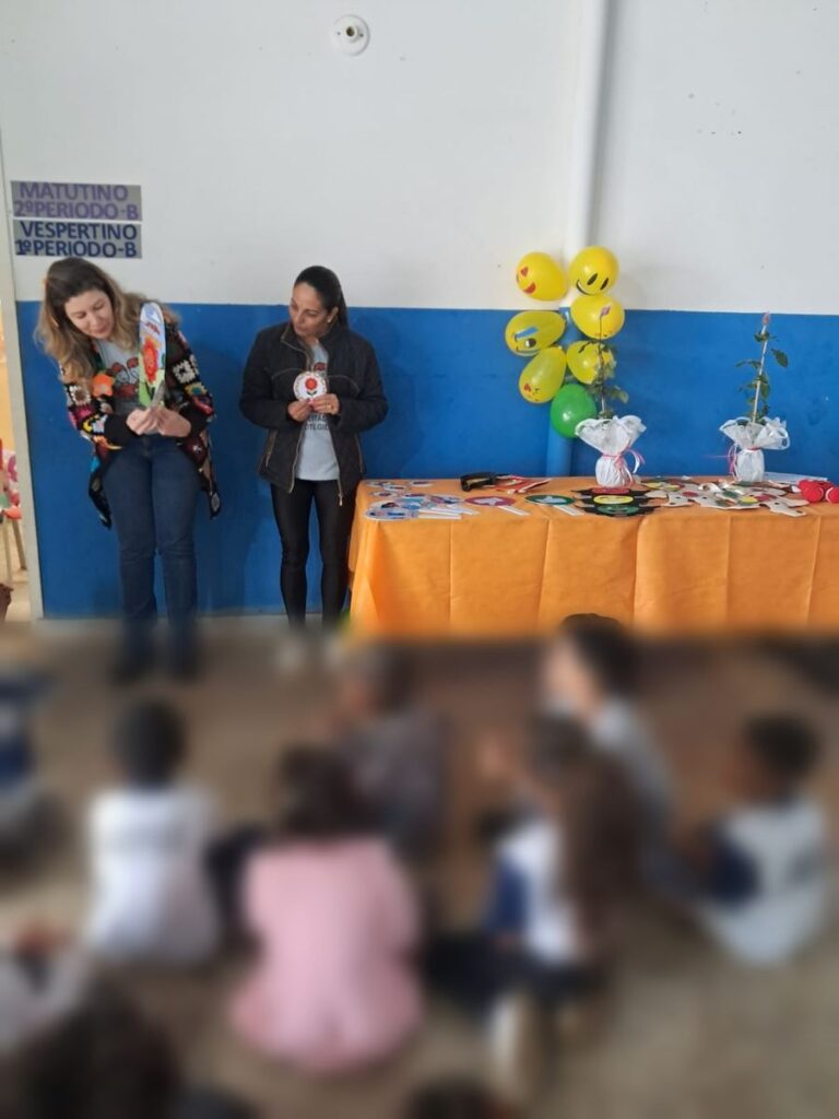 As crianças em volta da mesa de materiais do workshop